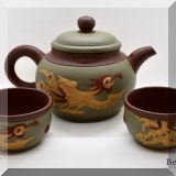 P29. Asian teapot with dragon and phoenix relief and two matching tea cups. - $65